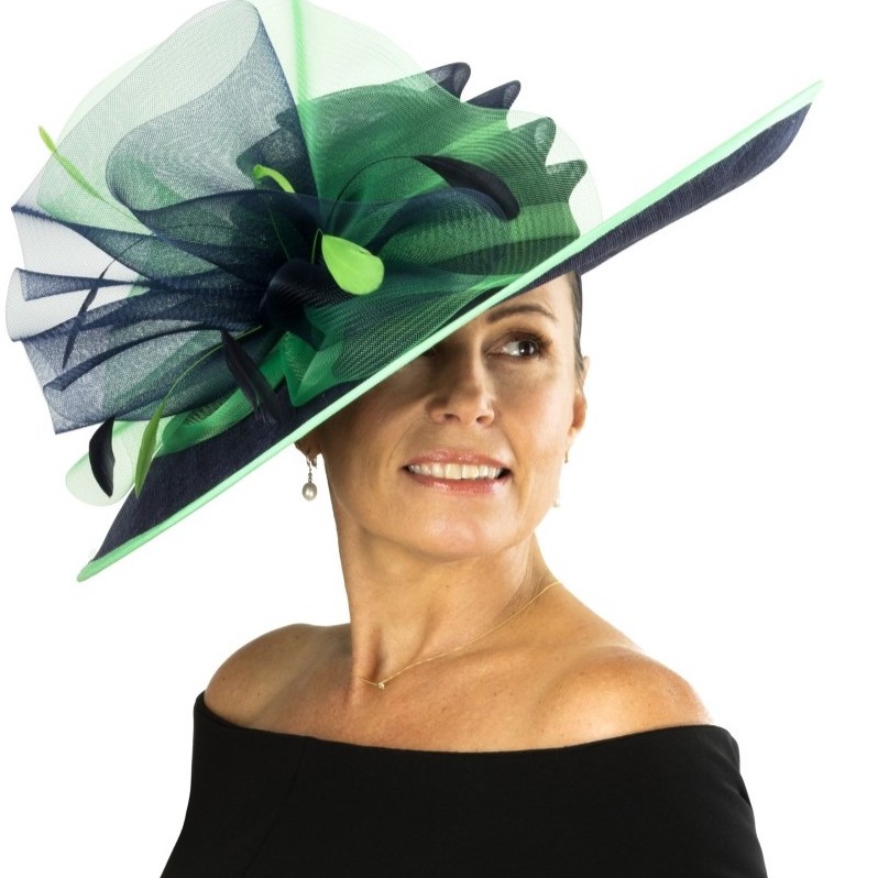 Elegant kvinde med bl&aring; og gr&oslash;n fascinator, perfekt til derby og festlige lejligheder