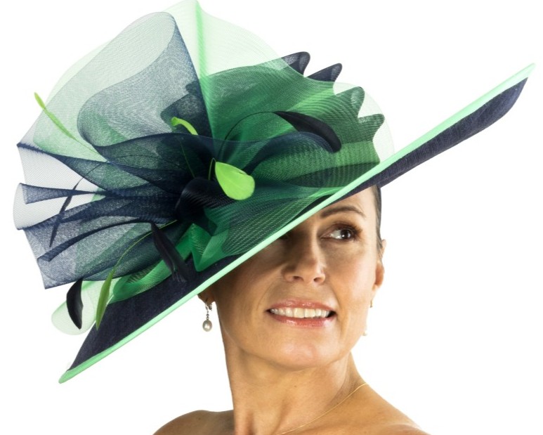 Elegant kvinde med bl&aring; og gr&oslash;n fascinator, perfekt til derby og festlige lejligheder